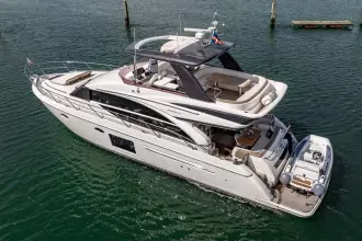 Luxurious 2015 Princess 60 yacht on serene water, featuring elegant design and spacious deck.