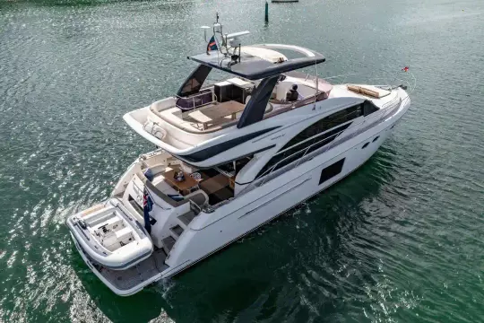 Luxurious 2015 Princess 60 yacht cruising on serene waters, showcasing elegant design and spacious deck.