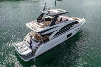 Luxurious 2015 Princess 60 yacht cruising on serene waters, showcasing elegant design and spacious deck.
