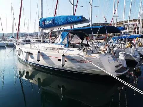 2013 Jeanneau Sun Odyssey 469 sailboat docked in marina, featuring blue sail cover.