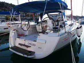 2013 Jeanneau Sun Odyssey 469 sailboat docked, featuring dual steering wheels and a blue canopy.