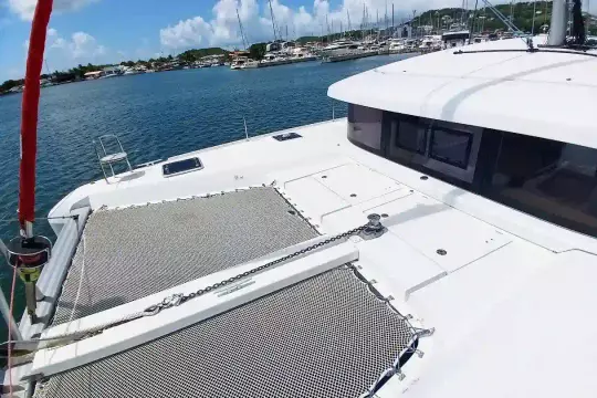 2020 Lagoon 42 catamaran with spacious deck and netting, docked in a marina.