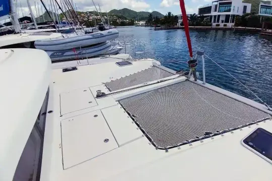 2020 Lagoon 42 catamaran docked in a scenic marina with surrounding boats.