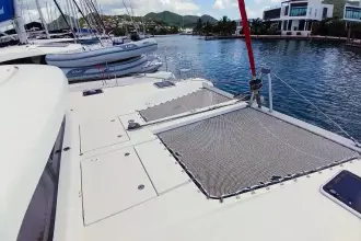 2020 Lagoon 42 catamaran docked in a scenic marina with surrounding boats.