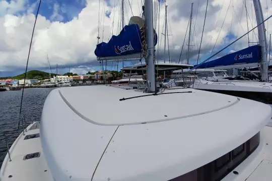 2020 Lagoon 42 catamaran docked at marina under cloudy sky.