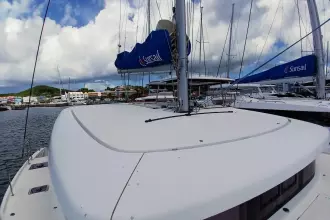 2020 Lagoon 42 catamaran docked at marina under cloudy sky.