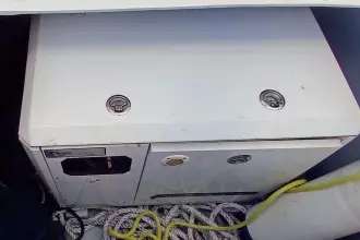 Storage compartment on a 2020 Lagoon 42 catamaran with ropes and yellow cable.