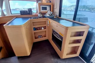 Modern kitchen interior of 2020 Lagoon 42 catamaran with appliances and scenic window view.