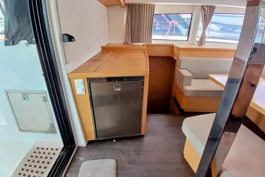 Interior of 2020 Lagoon 42 catamaran with seating area and compact kitchen.