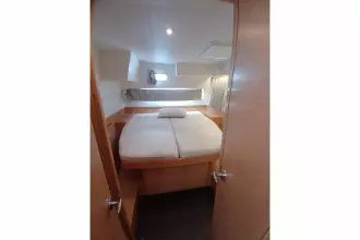 Cozy cabin interior of 2020 Lagoon 42 catamaran with comfortable bed and natural light.