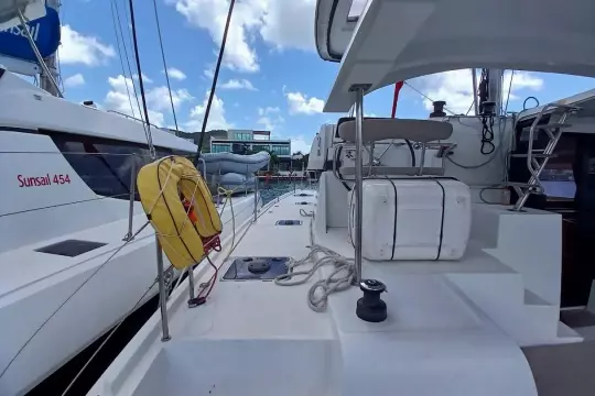 2020 Lagoon 42 catamaran deck view with life preserver and clear sky.