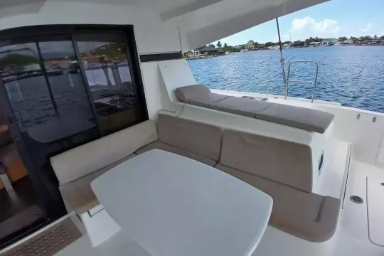 2020 Lagoon 42 yacht interior with seating and table, overlooking serene water.