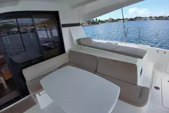 2020 Lagoon 42 yacht interior with seating and table, overlooking serene water.