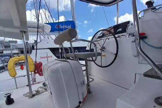 Helm of 2020 Lagoon 42 catamaran with steering wheel and nautical equipment.