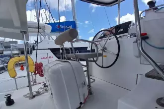 Helm of 2020 Lagoon 42 catamaran with steering wheel and nautical equipment.