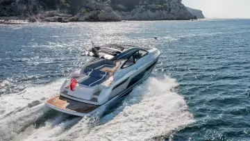 2025 Fairline Targa 50 Open yacht cruising on the ocean near rocky coastline.