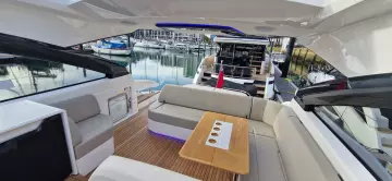 2025 Fairline Targa 45 Open yacht interior with seating and table, docked at marina.