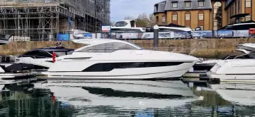 2025 Fairline Targa 45 Open yacht docked in a marina, reflecting on calm water.