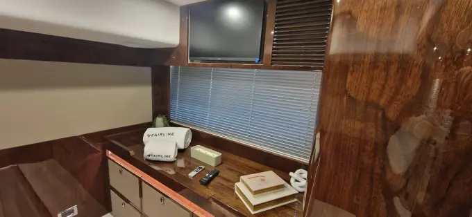 Luxurious interior of 2025 Fairline Targa 45 Open yacht with TV and wooden cabinetry.