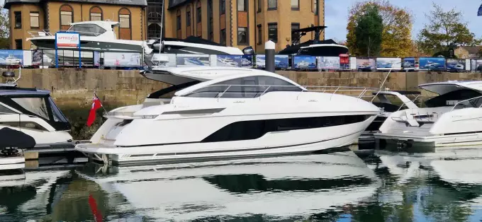 2025 Fairline Targa 45 Open yacht docked in a marina, reflecting on the water.