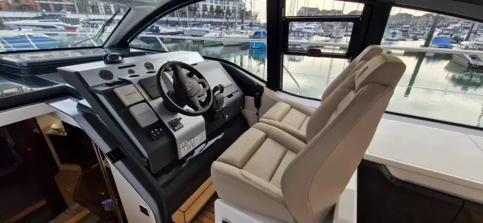2025 Fairline Targa 45 Open cockpit with modern controls and luxurious seating at marina.