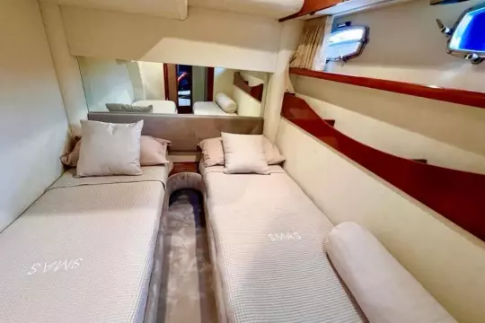 2006 Fairline Targa 52 GT cabin with twin beds, elegant wood accents, and porthole windows.