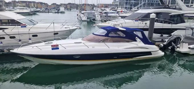 2003 Sunseeker Superhawk 34 yacht docked in a marina, surrounded by other boats.