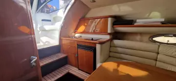 Interior of 2003 Sunseeker Superhawk 34 yacht, featuring wood cabinetry and seating area.