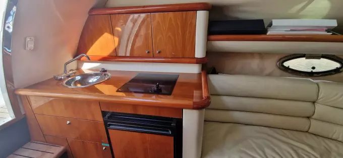 2003 Sunseeker Superhawk 34 interior with kitchenette, sink, stove, and seating area.