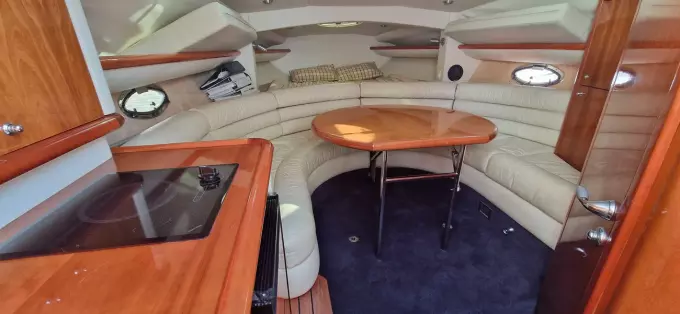 Luxurious interior of 2003 Sunseeker Superhawk 34 yacht with leather seating and wooden table.