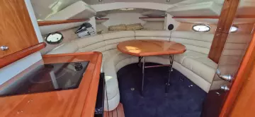 Luxurious interior of 2003 Sunseeker Superhawk 34 yacht with leather seating and wooden table.
