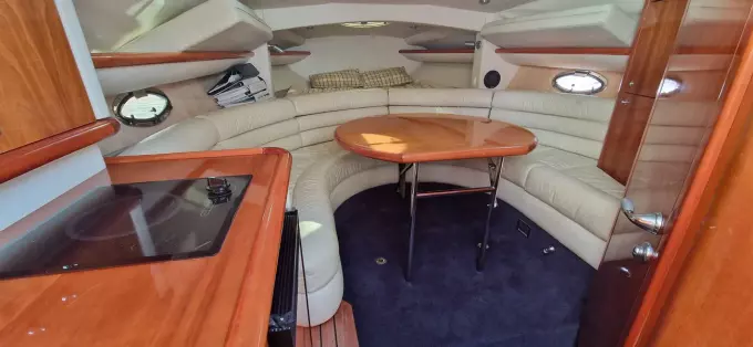 Interior of 2003 Sunseeker Superhawk 34 yacht with leather seating and wooden table.