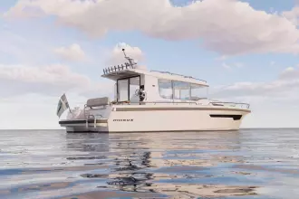 2026 Nimbus Commuter 12 boat on calm water under a partly cloudy sky.