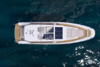 Top view of 2026 Nimbus Commuter 12 yacht with solar panels on blue water.