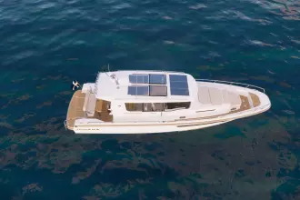 Aerial view of 2026 Nimbus Commuter 12 boat with solar panels on blue water.
