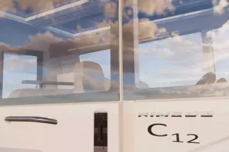 2026 Nimbus Commuter 12 with sleek design and modern interior, reflecting sky in windows.