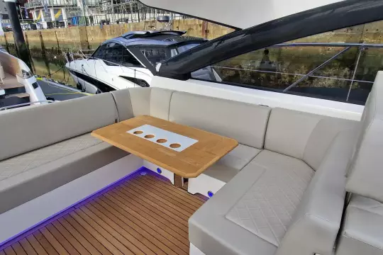 Luxurious seating area on 2024 Fairline Targa 45 Open yacht with elegant wood table.