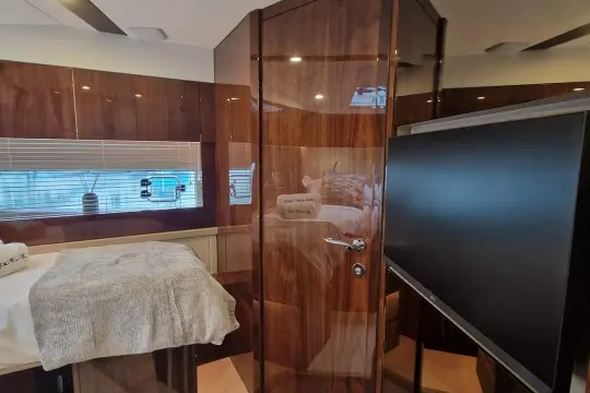 2024 Fairline Targa 45 Open interior with wood finish, bed, and TV.