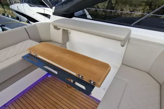 Luxurious seating area on 2024 Fairline Targa 45 Open yacht with wooden table.