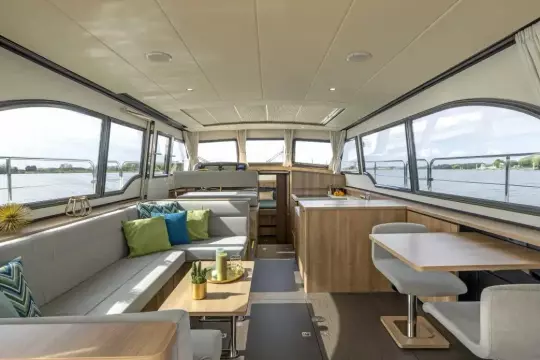 Luxurious interior of 2025 Linssen 45 SL Sedan yacht with modern furnishings and panoramic windows.