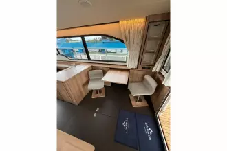 Interior of 2025 Linssen 45 SL Sedan yacht with modern seating and large windows.