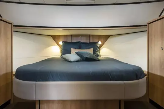 Luxurious bedroom interior of 2025 Linssen 45 SL Sedan yacht with elegant bedding.