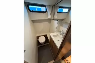 Bathroom interior of 2025 Linssen 45 SL Sedan yacht, featuring toilet and sink.