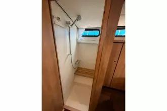 Shower area in 2025 Linssen 45 SL Sedan yacht with wooden accents and window.