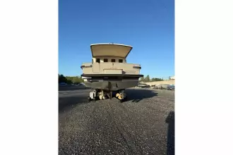 2025 Linssen 45 SL Sedan yacht on gravel lot, rear view under clear blue sky.