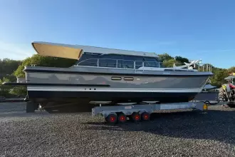 2025 Linssen 45 SL Sedan yacht on trailer, parked outdoors under clear sky.