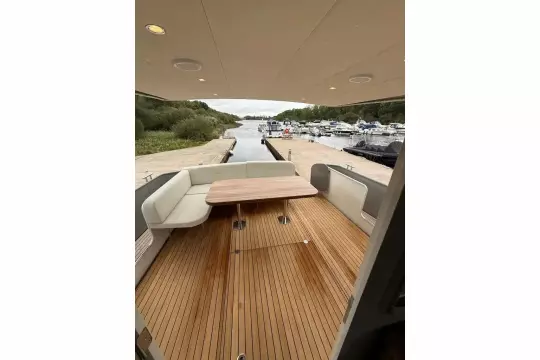 2025 Linssen 45 SL Sedan yacht with elegant teak deck and seating area at a marina.