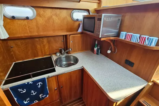 2008 Linssen Grand Sturdy 380 AC yacht kitchen with stove, sink, microwave, and mugs.