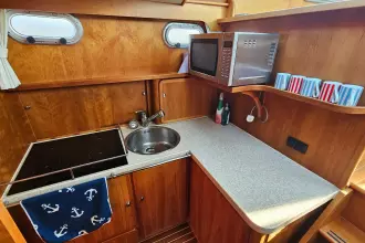 2008 Linssen Grand Sturdy 380 AC yacht kitchen with stove, sink, microwave, and mugs.