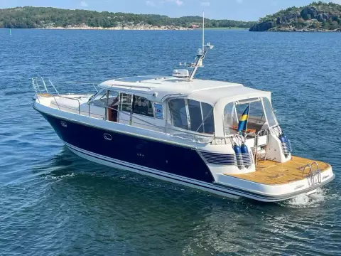 Nimbus 42 Nova 2008 boat cruising on a scenic lake with forested shoreline.